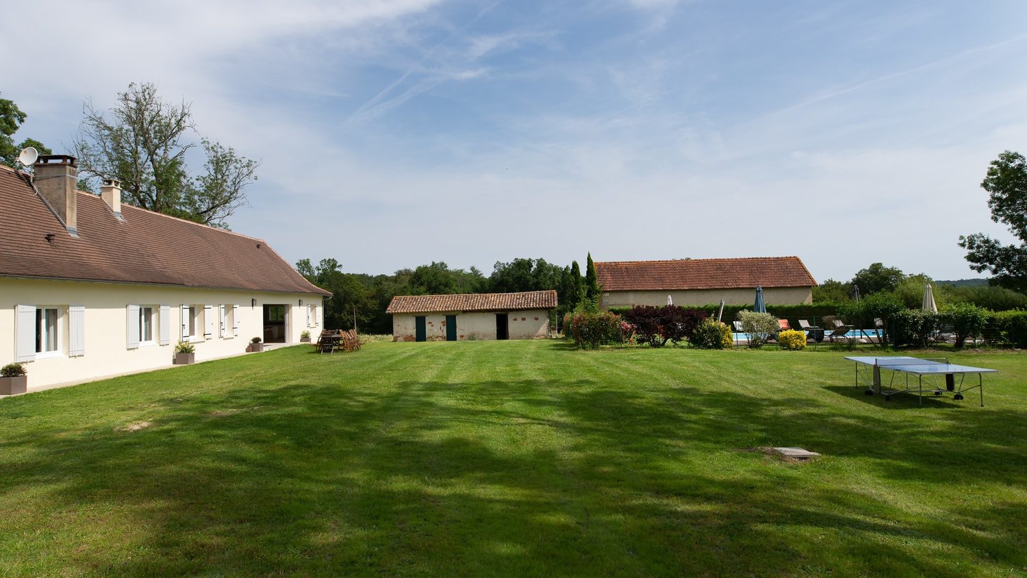 Le domaine vu de la grande pelouse : les gîtes, les dépendances et la piscine au fond